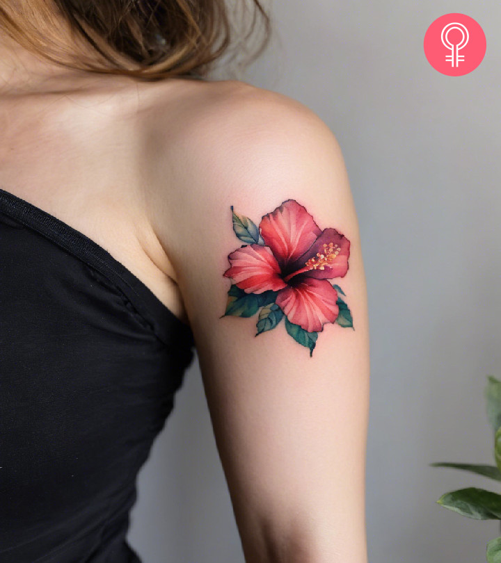 A woman with a hibiscus tattoo on her upper arm