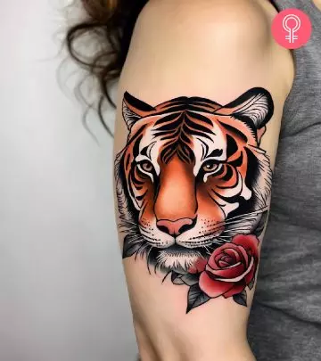 A woman with a colorful tiger rose tattoo on her upper arm