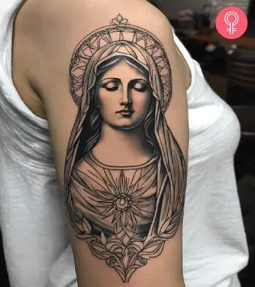 Woman with a black and gray portrait tattoo of the Virgin Mary on the upper arm