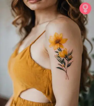 A woman with a vibrant yellow flower tattoo on her upper arm