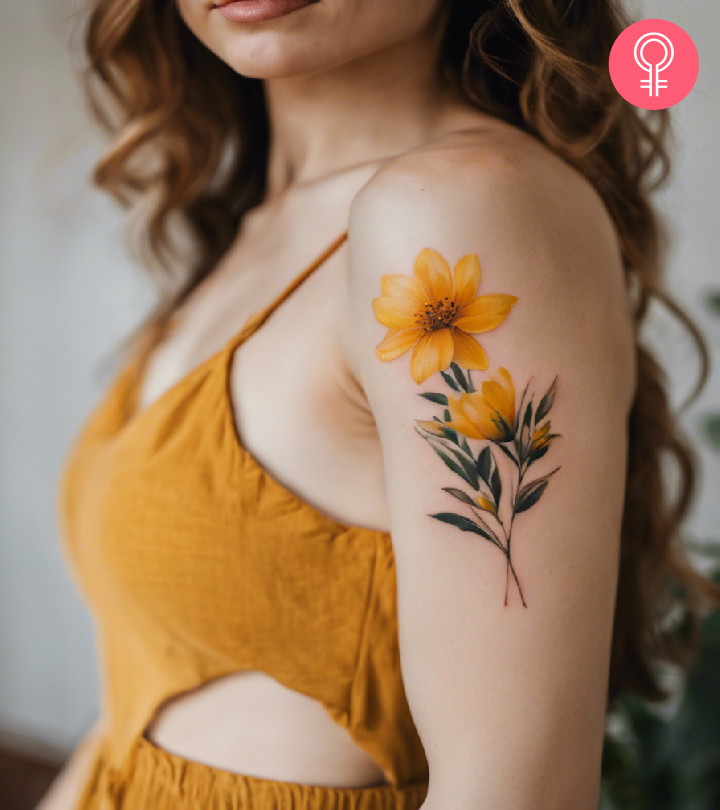 A woman with a vibrant yellow flower tattoo on her upper arm