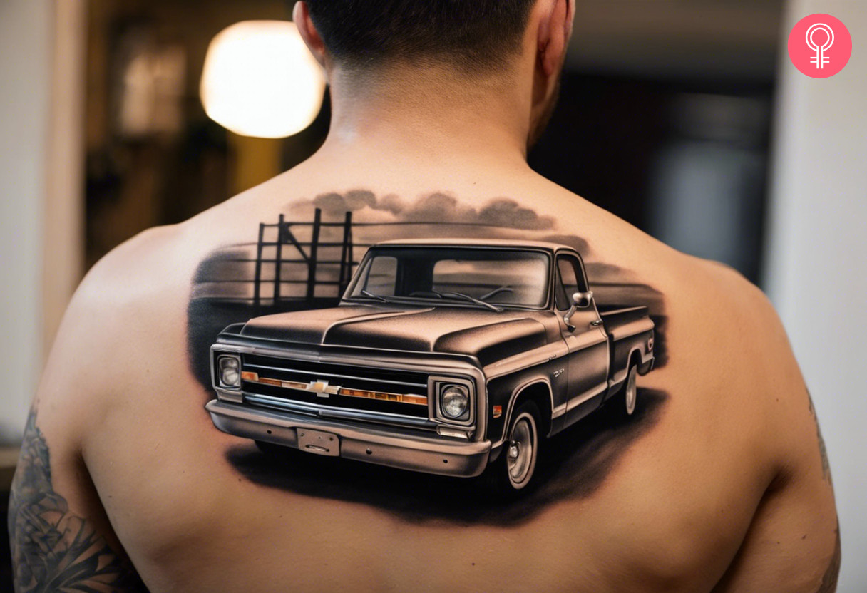 A black and grey Chevy C10 tattoo on the upper back