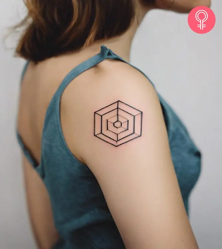 A fine line geometrical hexagon tattoo on the upper arm