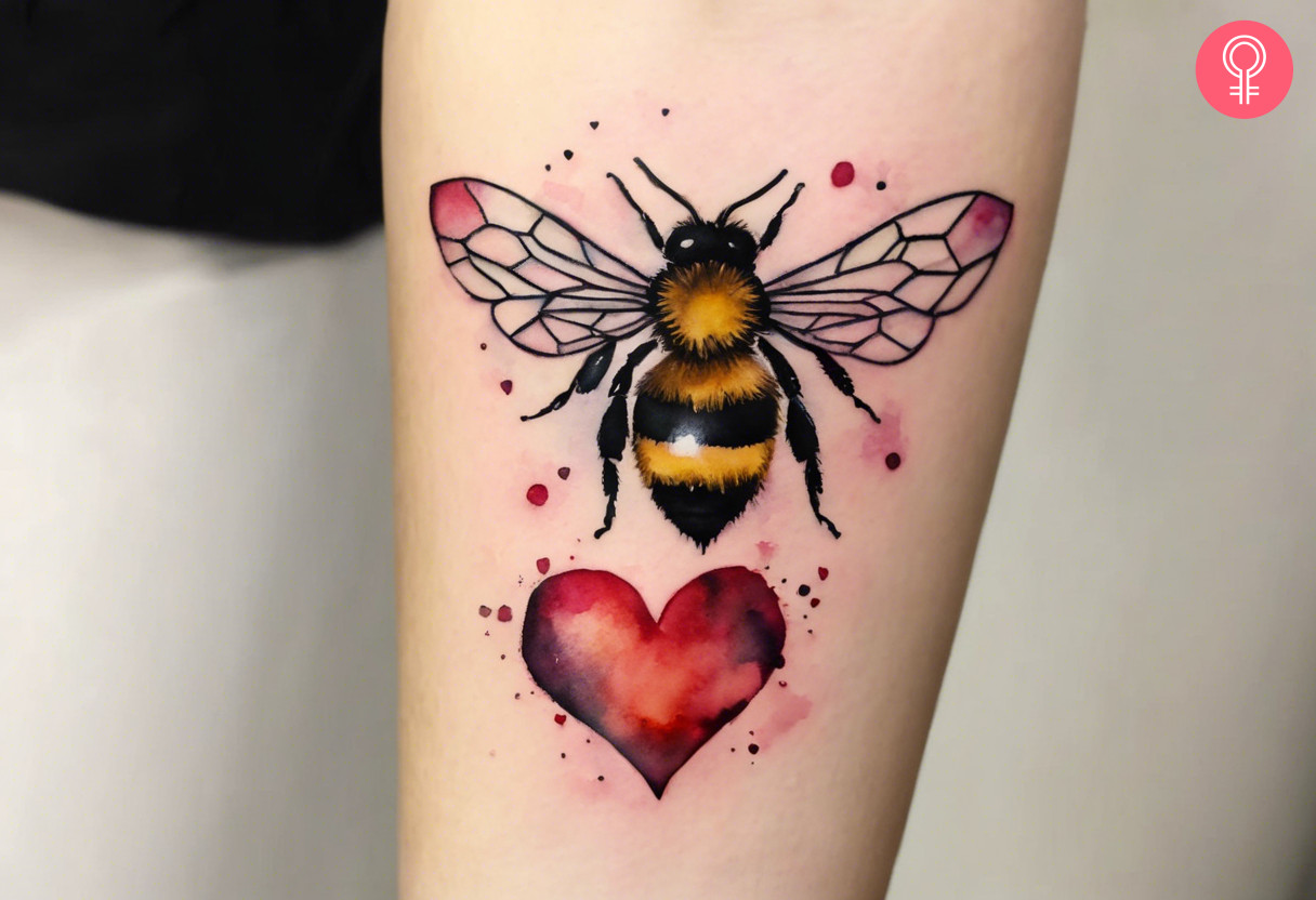 A girly bee and heart tattoo on the forearm of a woman