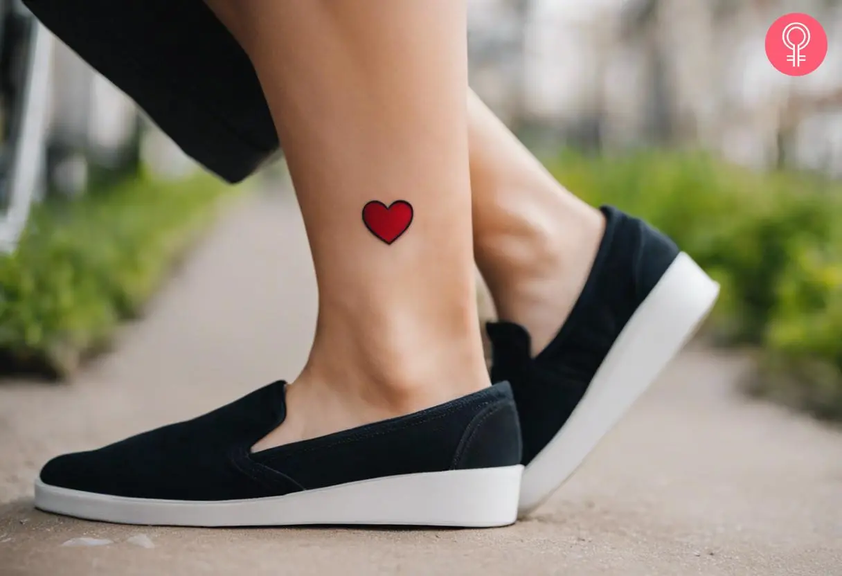 A heart emoji tattoo on a woman’s ankle