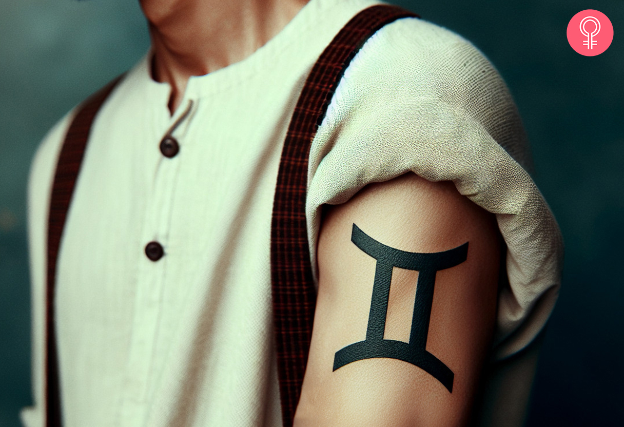 A man wearing a Gemini zodiac tattoo on the upper arm