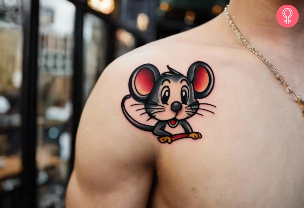 A man wearing a cartoon mouse tattoo on the front shoulder