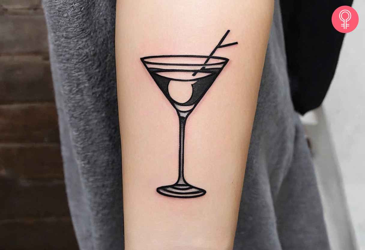 A martini tattoo on the forearm inked in black.