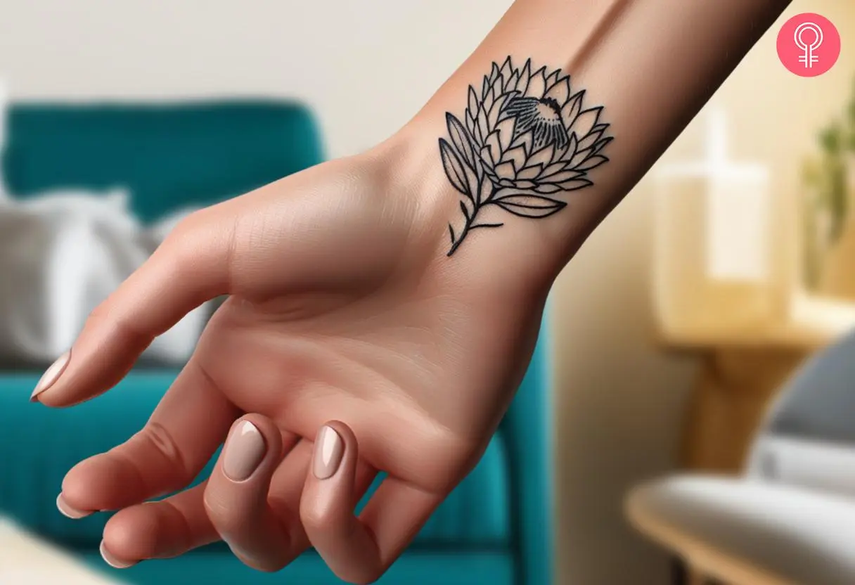 A minimalist protea tattoo inked on a woman’s inner wrist