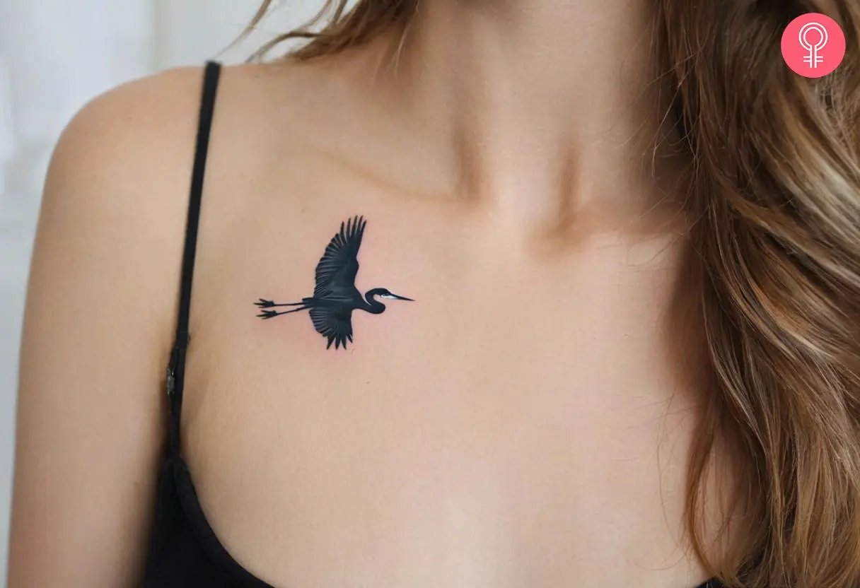 A minimalistic heron tattoo below the collarbone