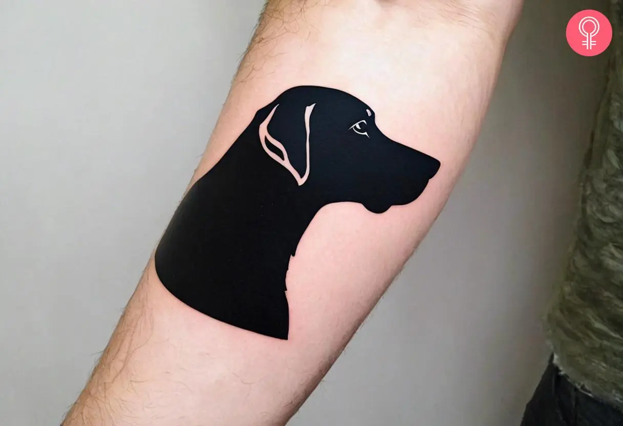 A silhouette of a dog bust on the forearm