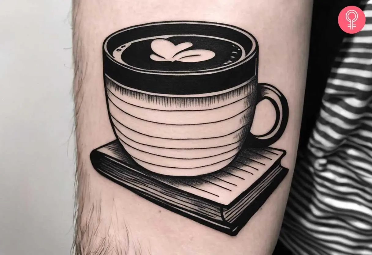 A traditional coffee with book tattoo on the forearm