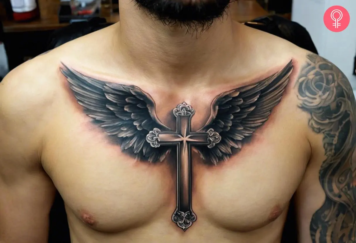 A traditional cross tattoo with wings inked on the chest