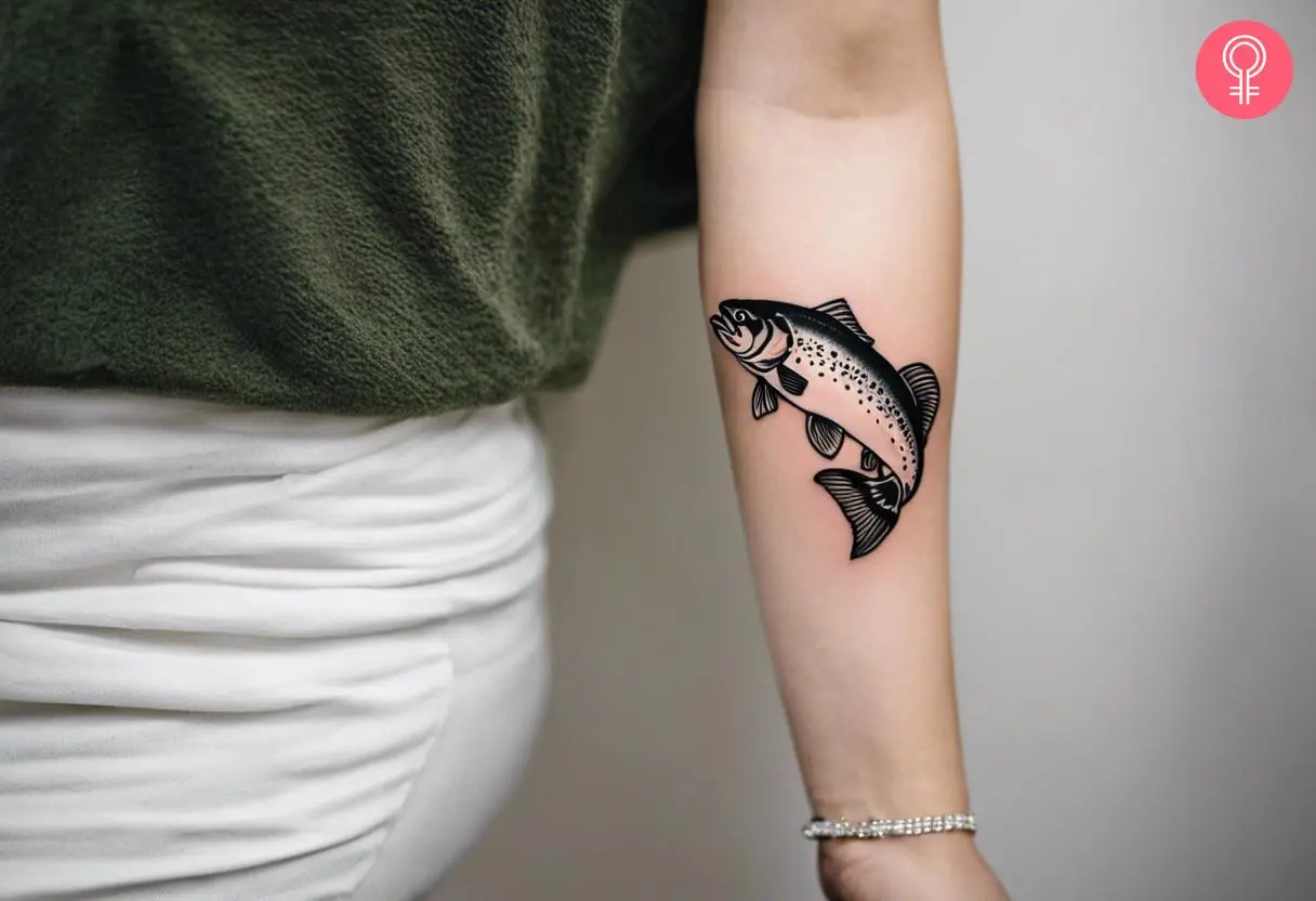 A traditional outline trout inked on the forearm.