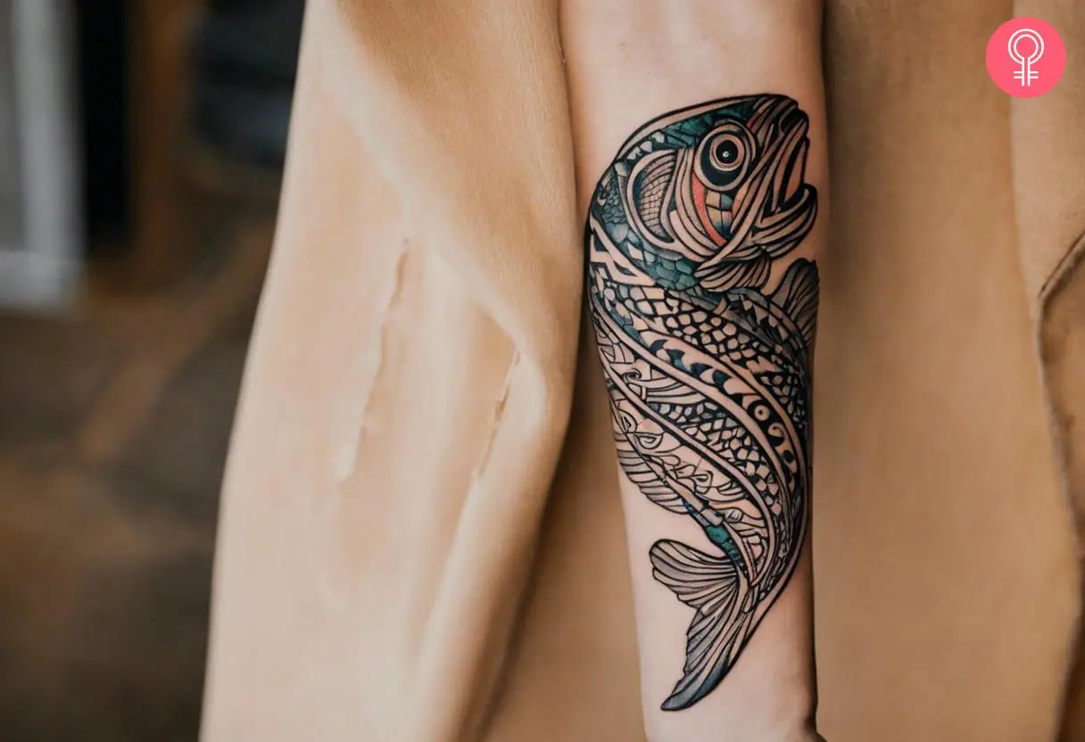 A tribal trout inked on the forearm.