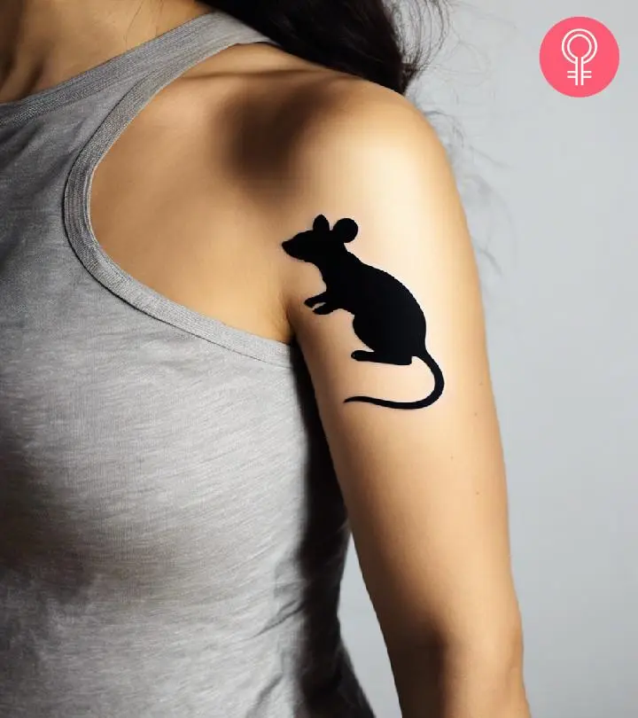 A woman wearing a ‘minimalist mouse’ tattoo on the upper arm.