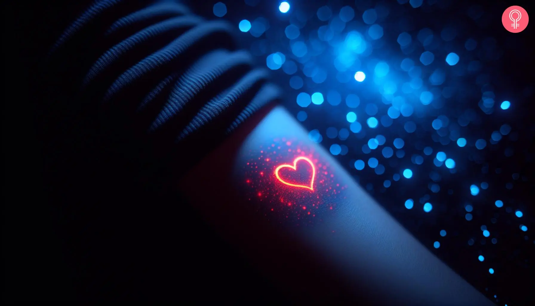 A woman wearing a red glow-in-the-dark heart tattoo on her lower arm