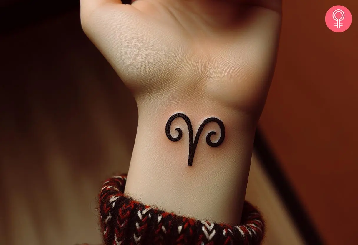 A woman wearing an Aries zodiac tattoo on the wrist