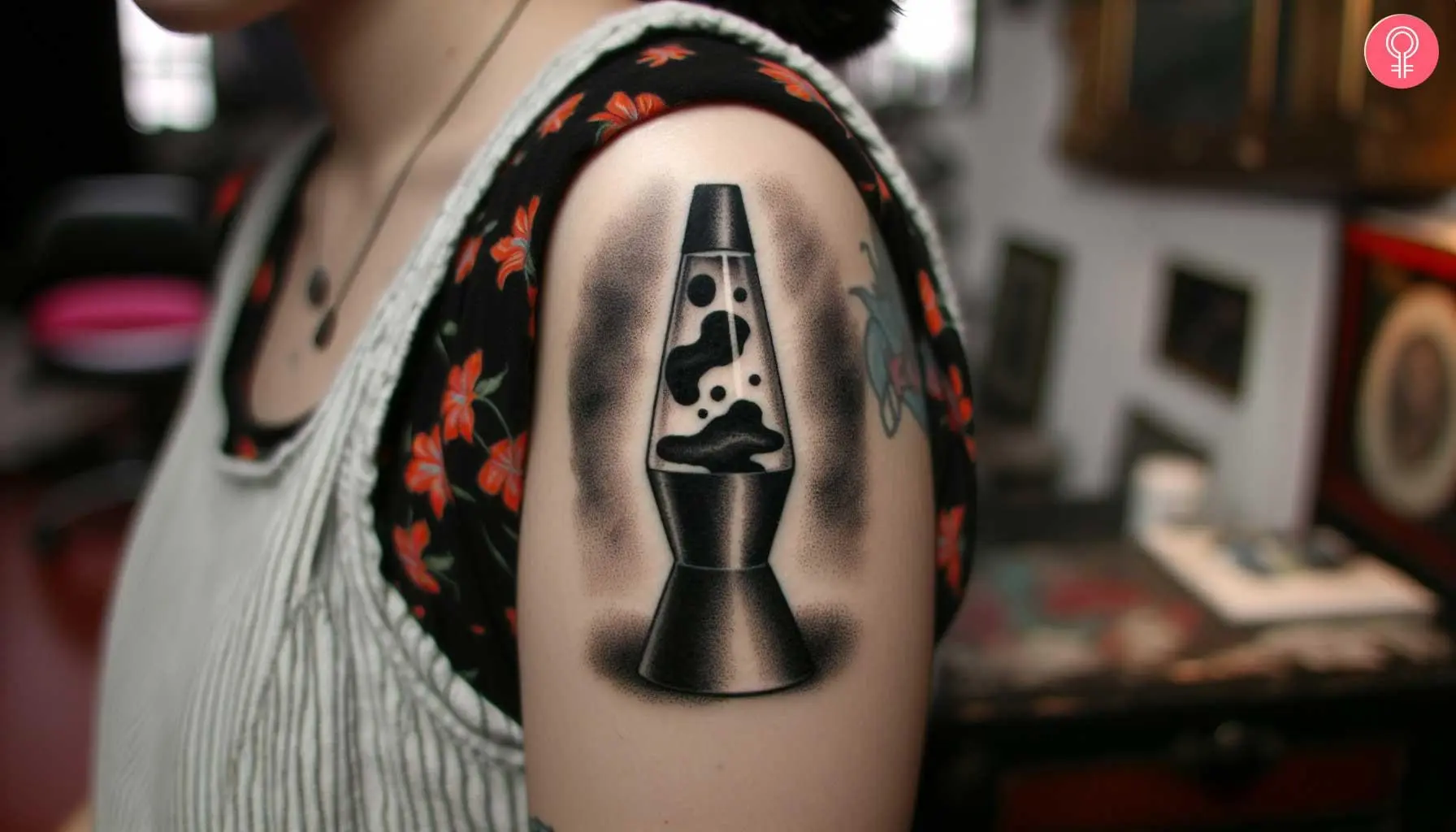 A woman with a black lava lamp tattoo on her upper arm