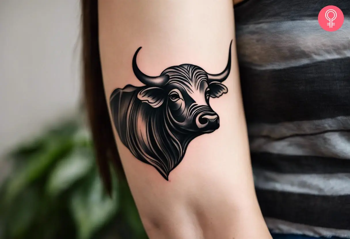 A woman with a black water buffalo tattoo on her upper arm