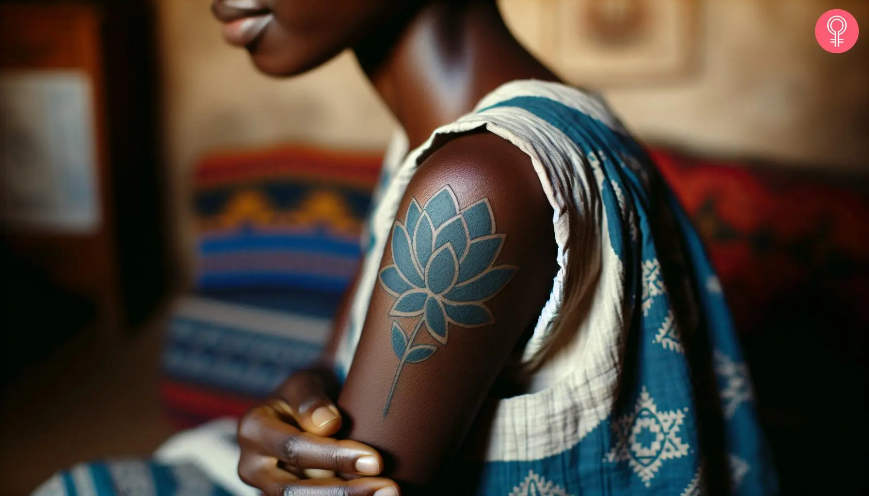 A woman with a blue lotus mandala tattoo on her upper arm