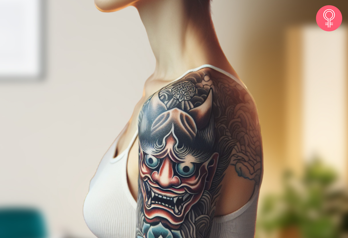 A woman with a colored Japanese demon oni mask tattoo on her upper arm