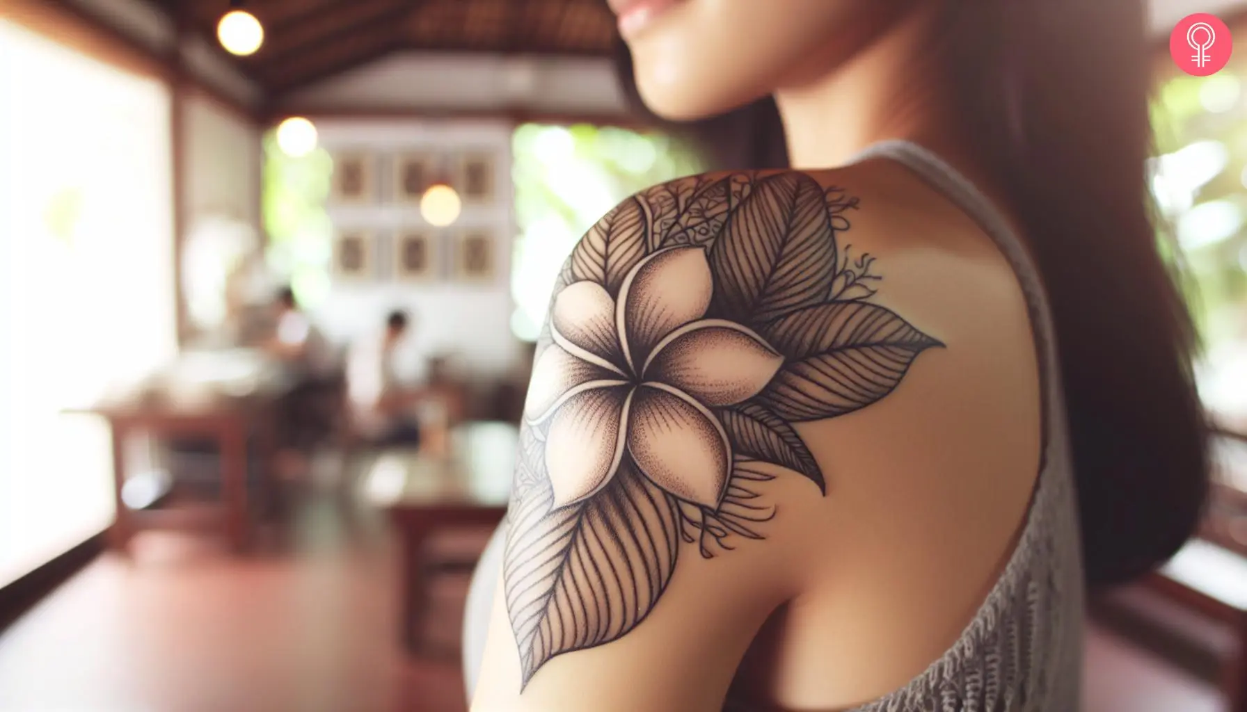 A woman with a fine line frangipani flower tattoo on her shoulder cap  