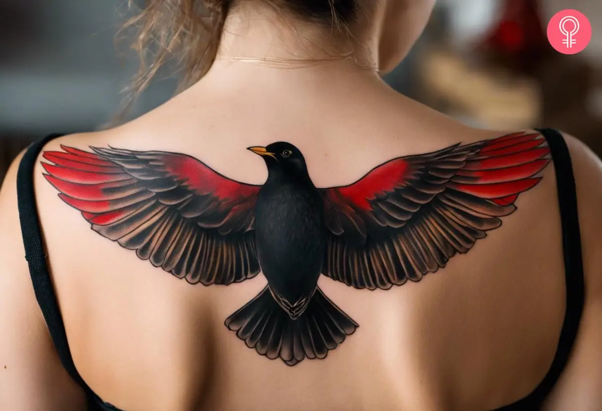 A woman with a flying blackbird tattoo on her back