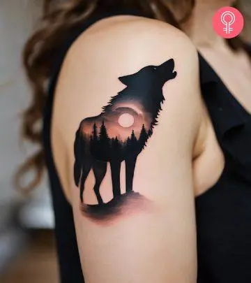 A woman with a howling wolf tattoo on her upper arm