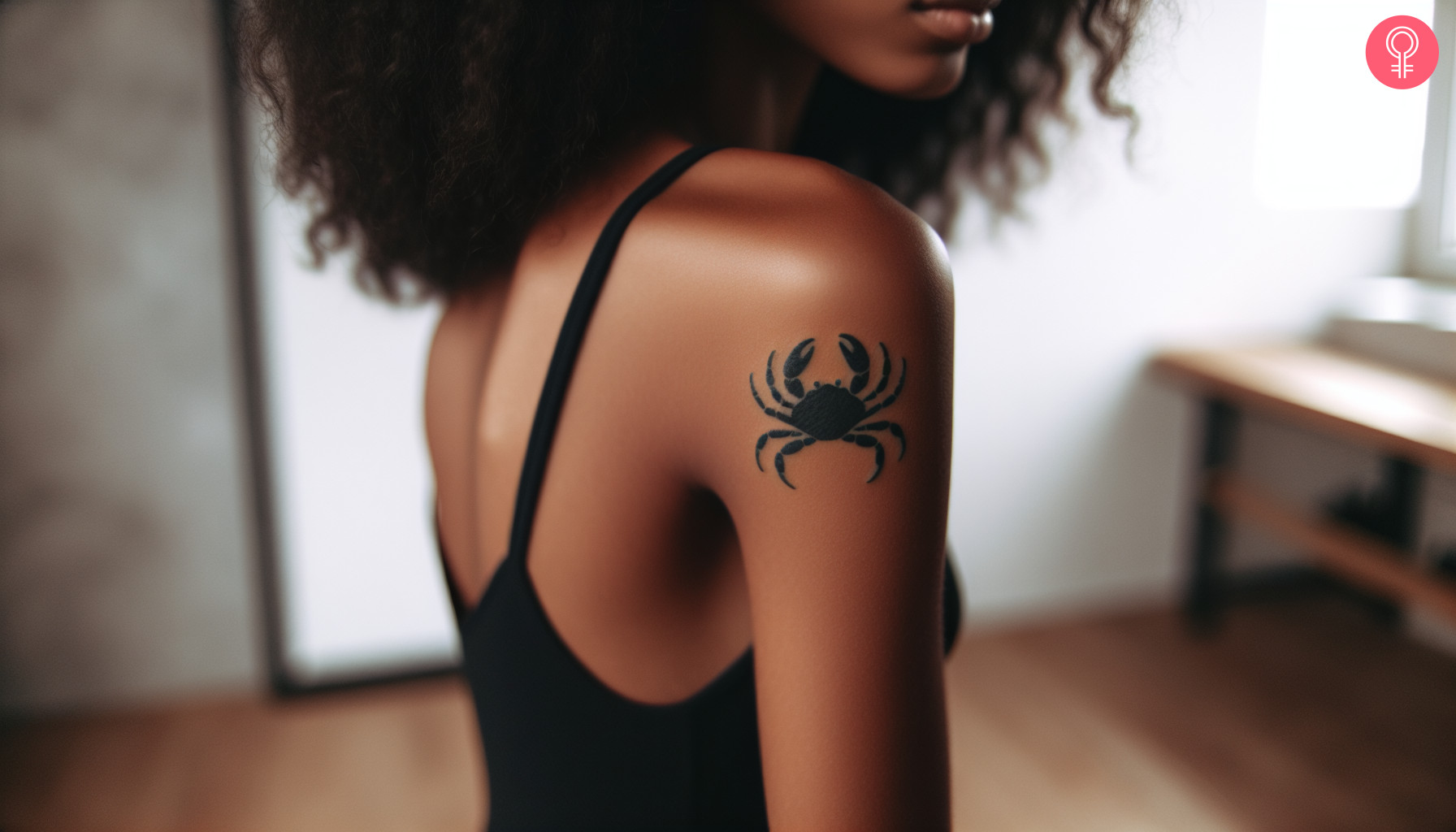 A woman with a minimalist crab tattoo on her upper arm