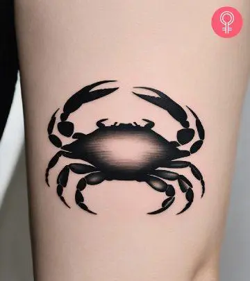 A woman with a minimalist crab tattoo on her upper arm