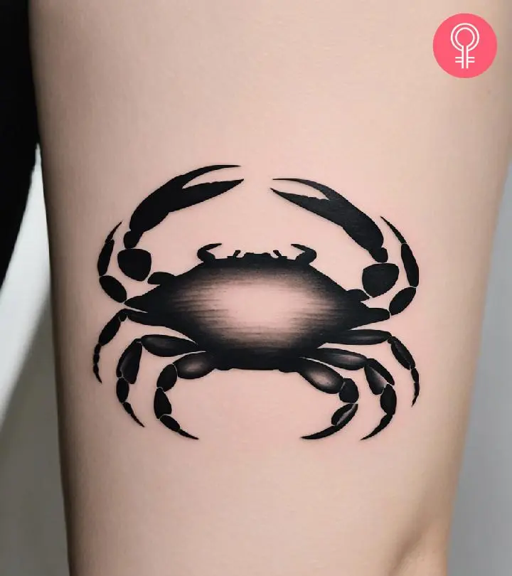 A woman with a minimalist crab tattoo on her upper arm