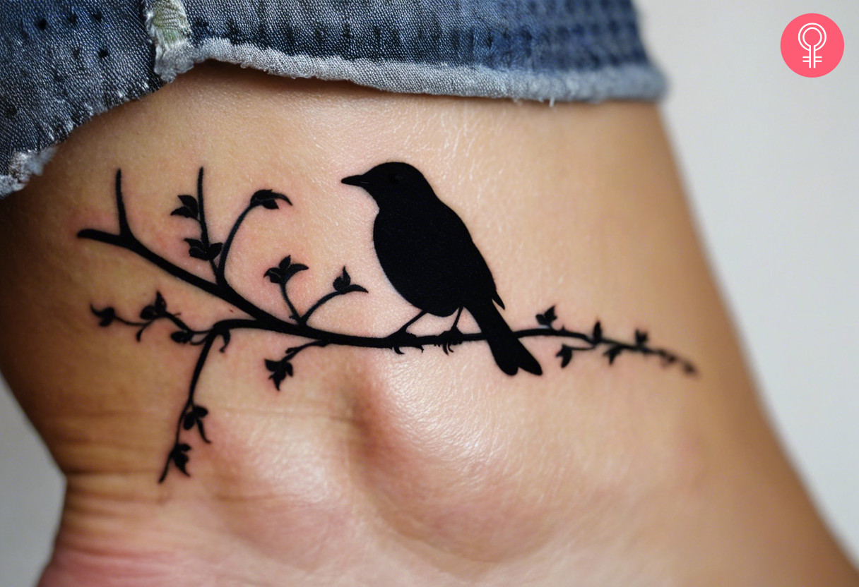 A woman with a silhouette blackbird tattoo on her ankle