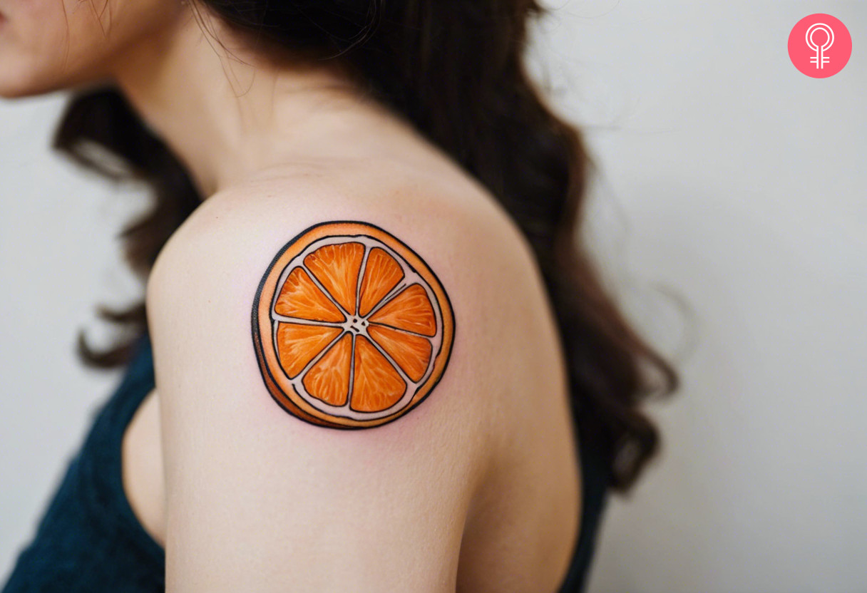 A woman with a vibrant half orange tattoo on her shoulder