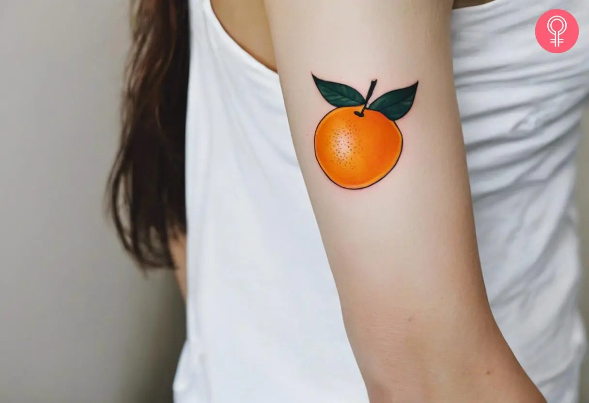 A woman with a vibrant traditional orange tattoo on her upper arm