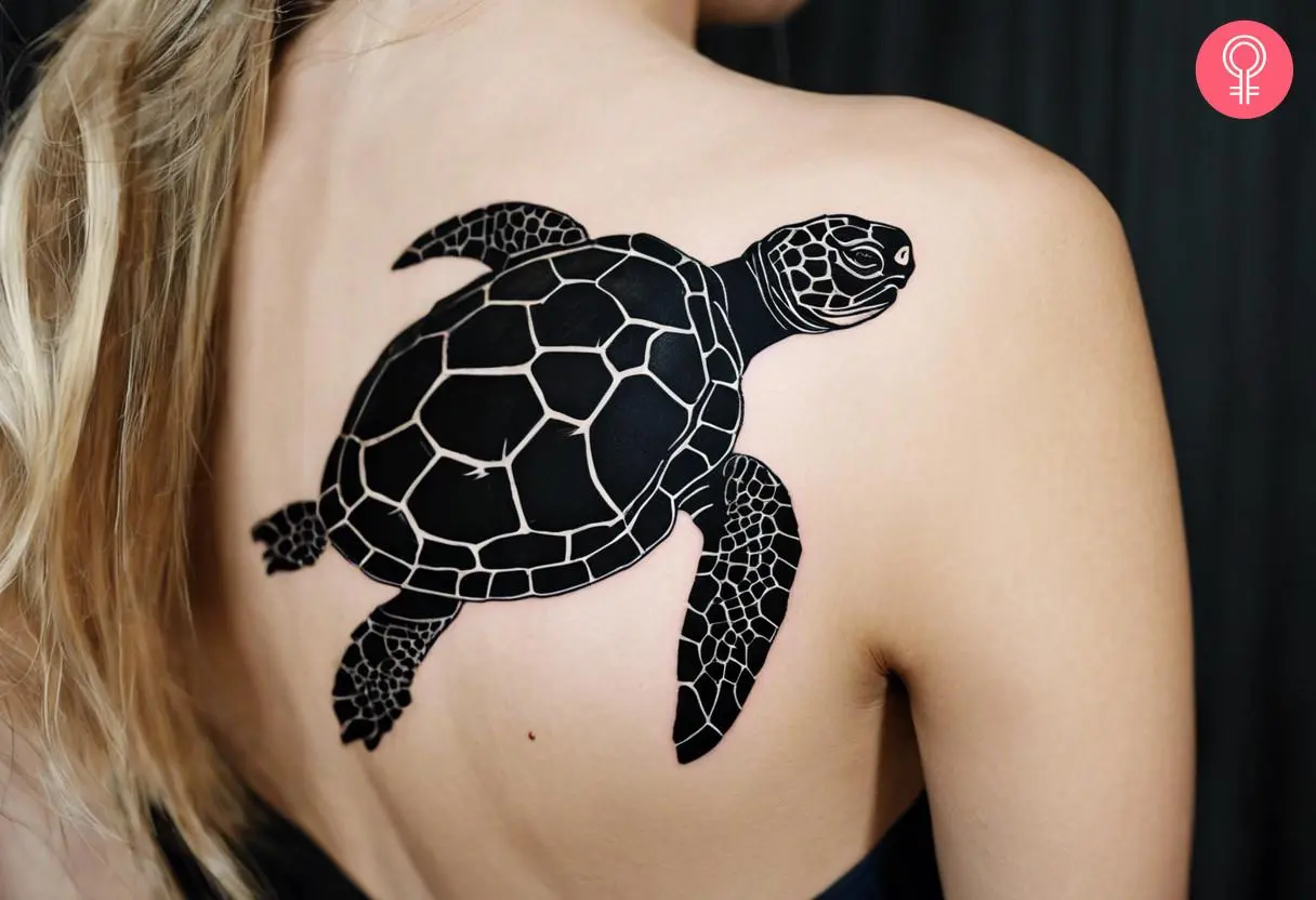 A woman with black tortoise tattoo on her upper back