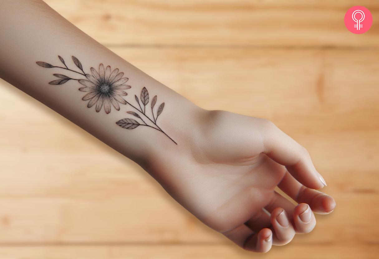 A faded daisy flower on the inside of the wrist