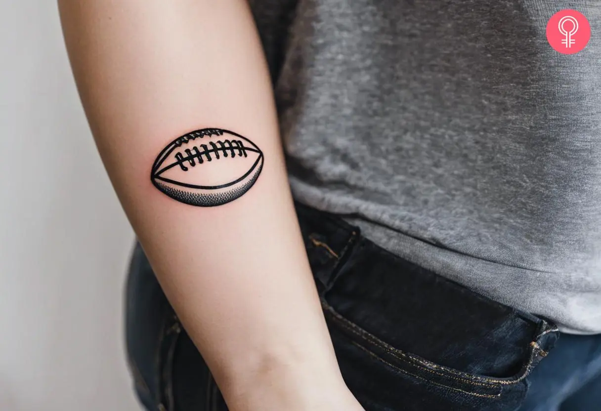 American football ball tattoo on a woman’s forearm