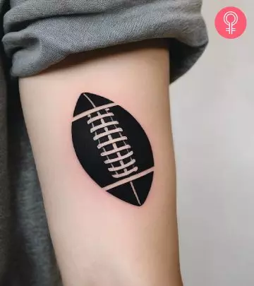 American football ball tattoo on the arm