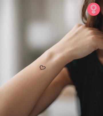 A woman with a simple heart tattoo on her wrist