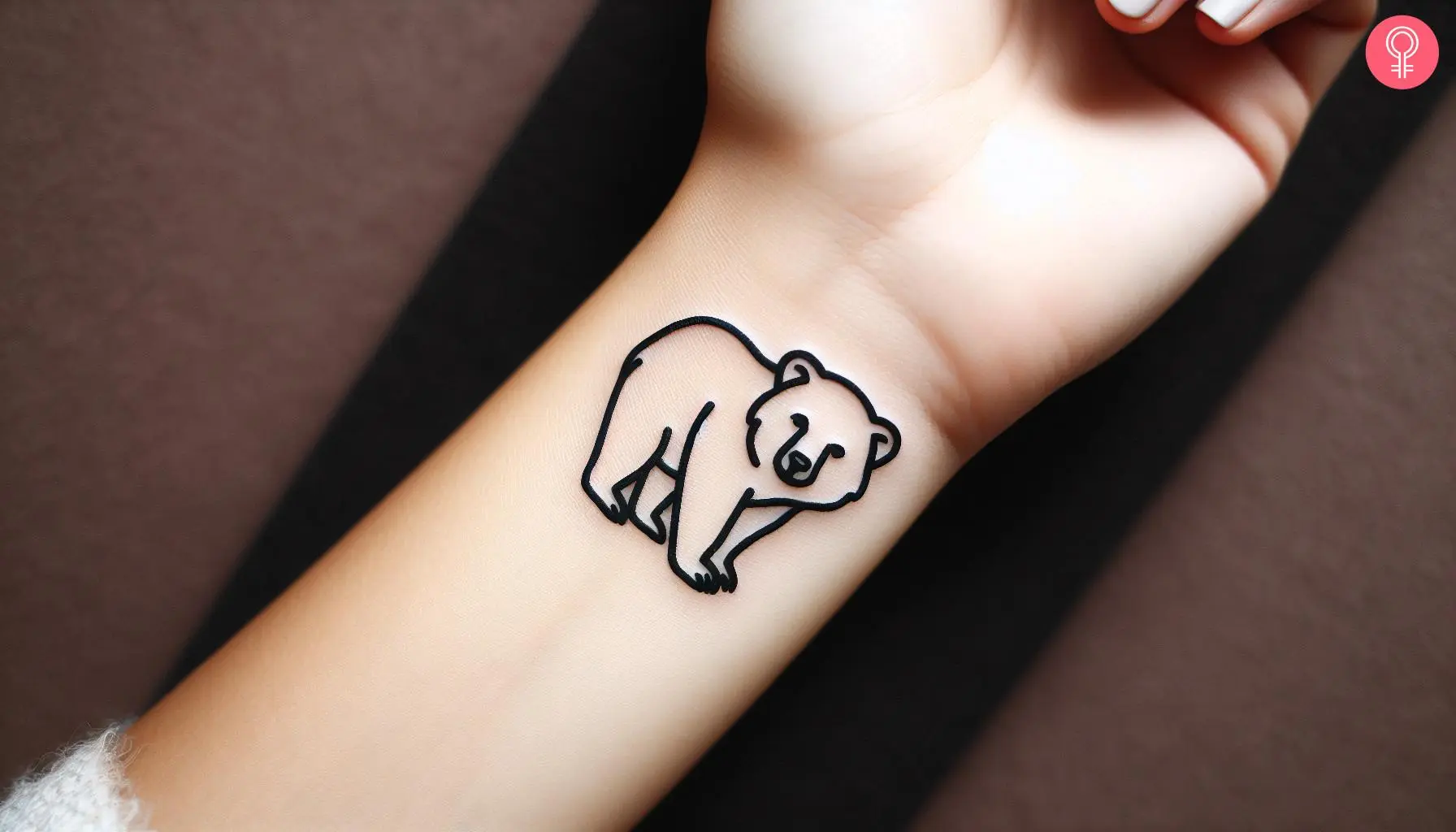 Woman with outline bear cub tattoo on her wrist