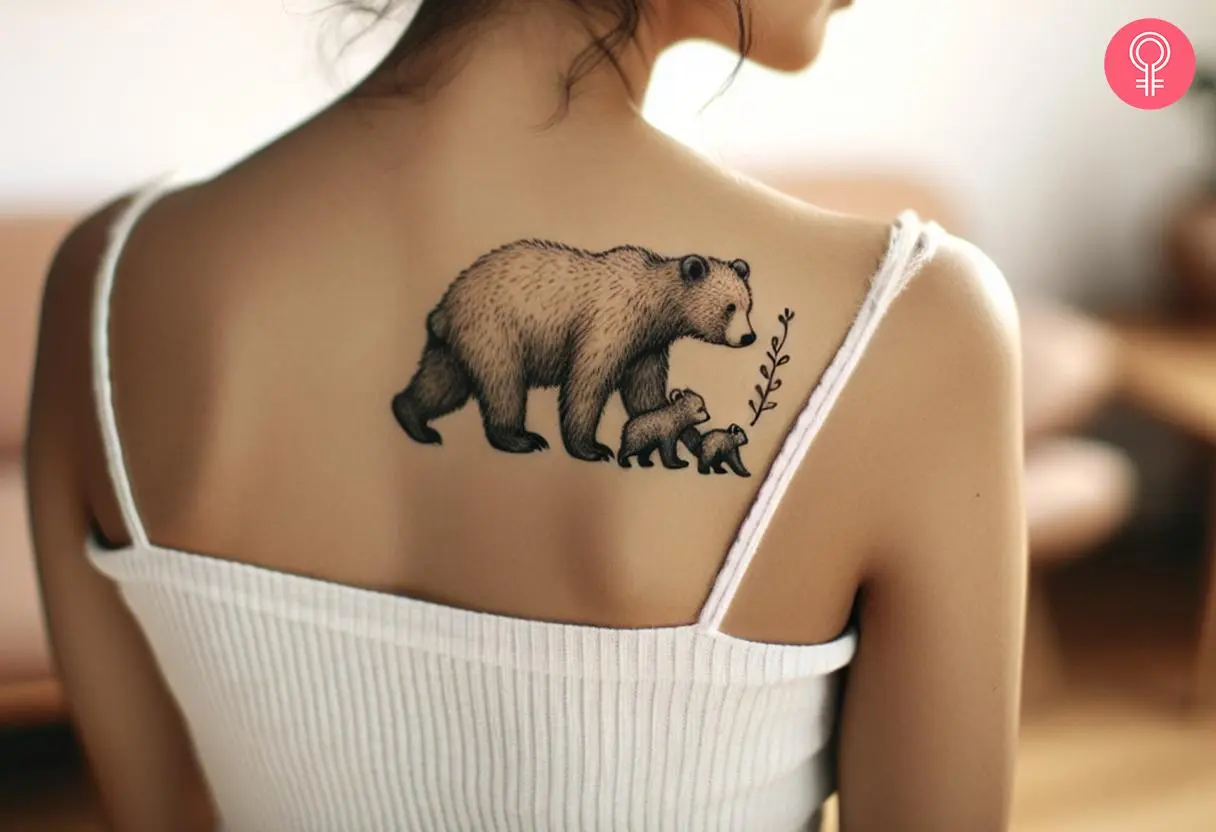 A woman with a bear protecting cubs tattoo on her upper back