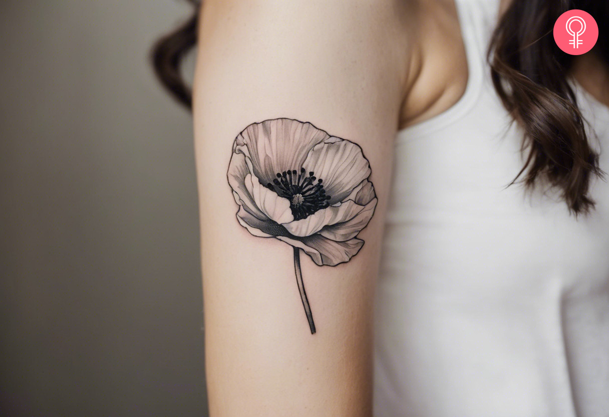 An August birth flower tattoo in black and white ink on a woman’s bicep