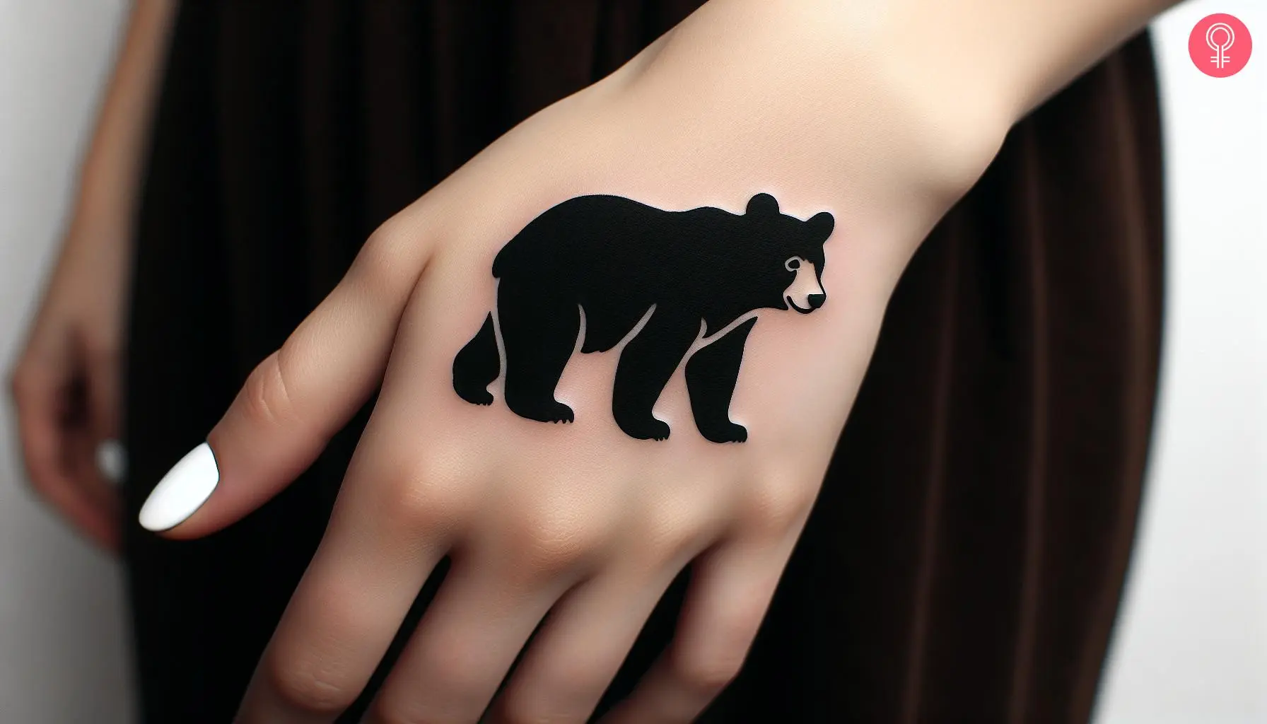 Woman with black bear cub tattoo on her hand