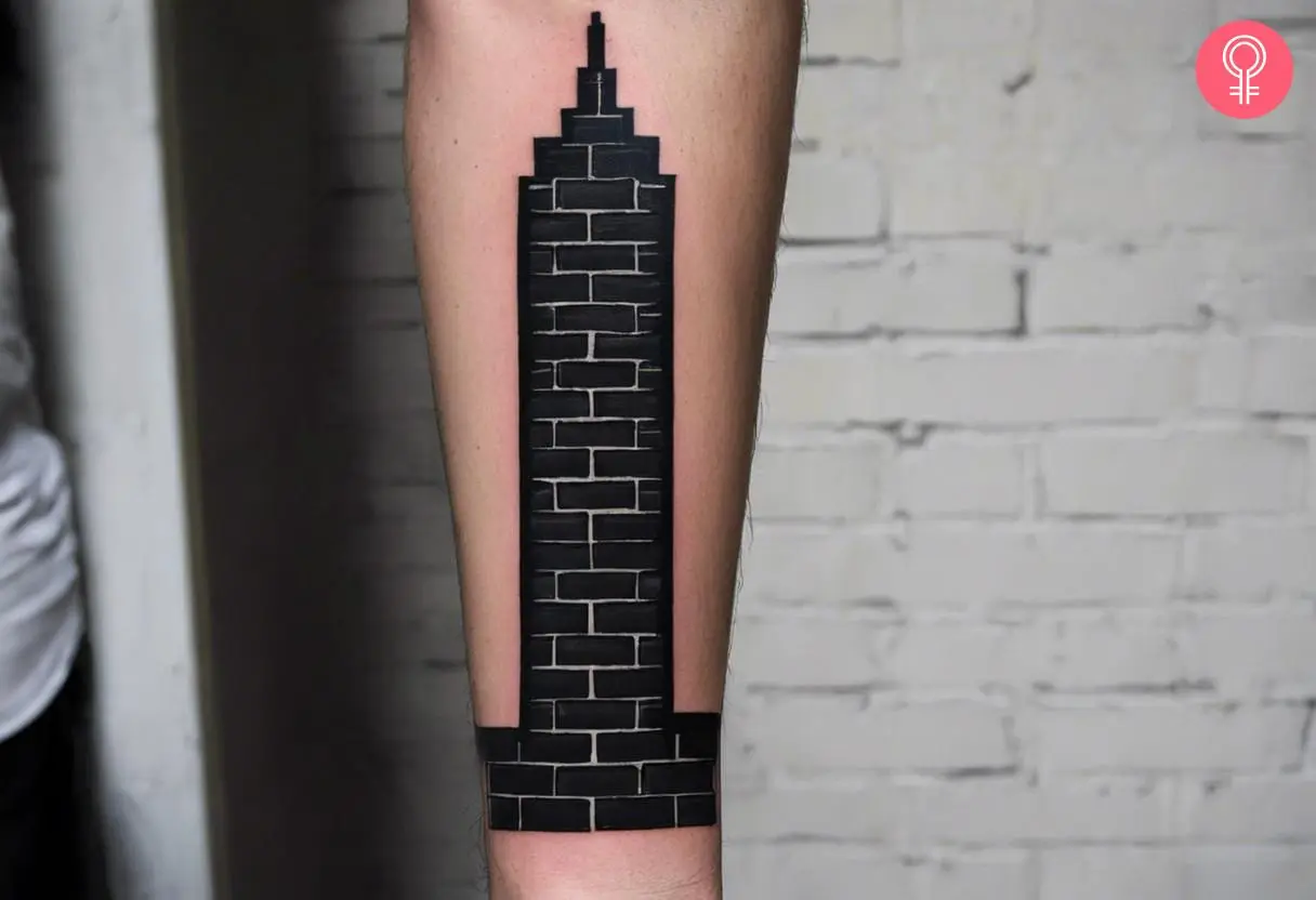 A black wall pillar tattoo on the forearm