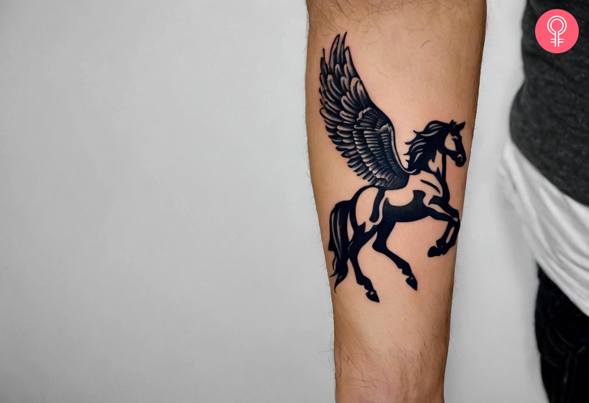 A black ink Pegasus tattoo on the forearm.