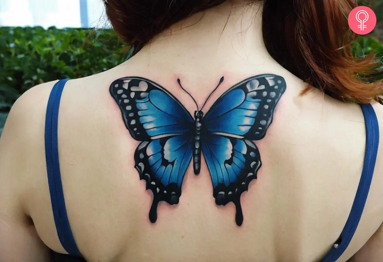 A woman with a blue and black butterfly tattoo on her back