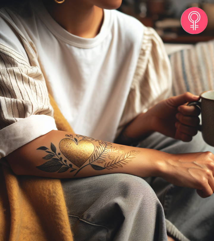 A woman with a golden heart tattoo on her arm