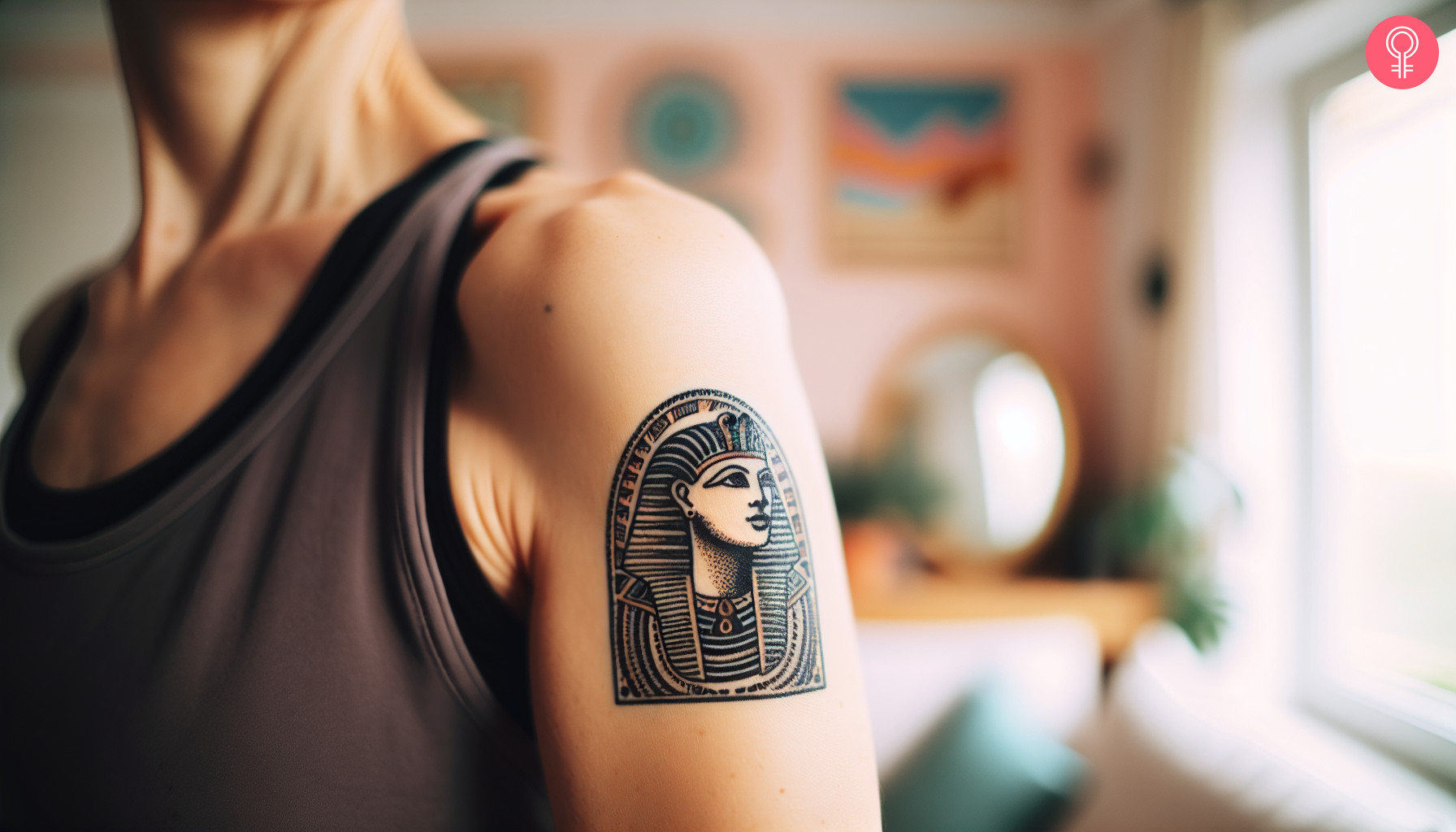 A woman with a small colored Cleopatra tattoo on her upper arm