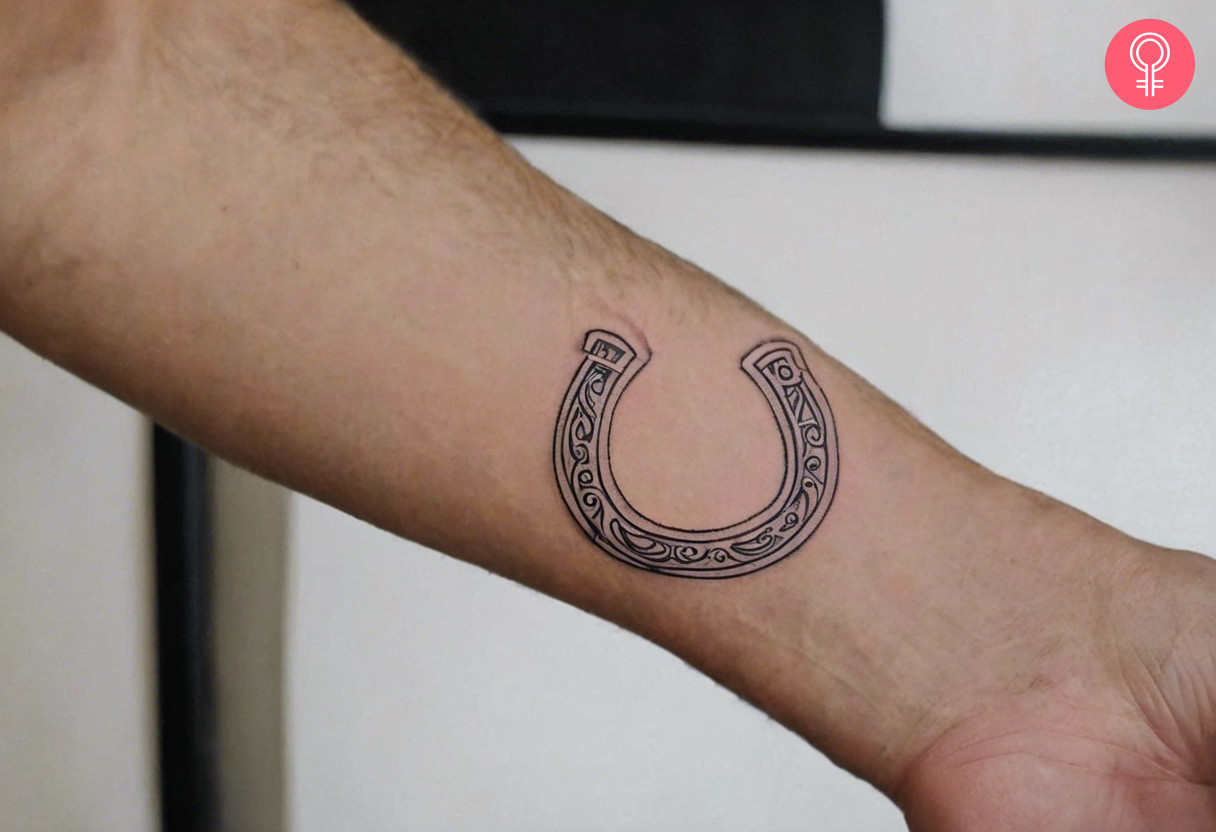 Dainty horseshoe tattoo on the forearm